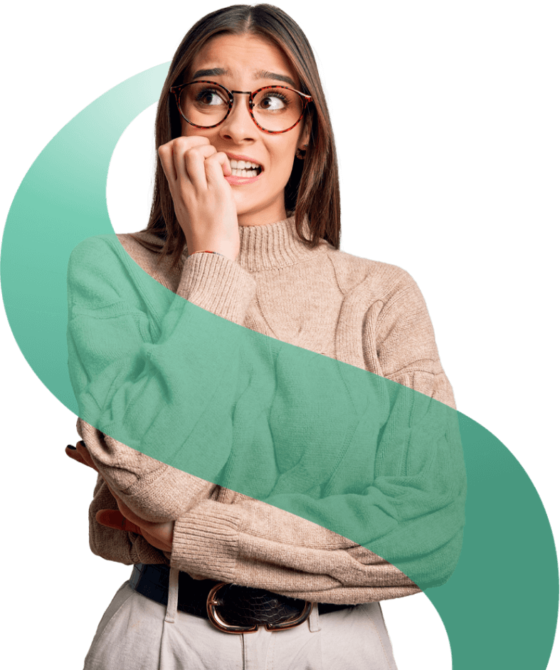 Dekle zaskrbljeno drži dlan pri ustih in gleda na stran, oblečena je v bež pulover in na obrazu ima očala