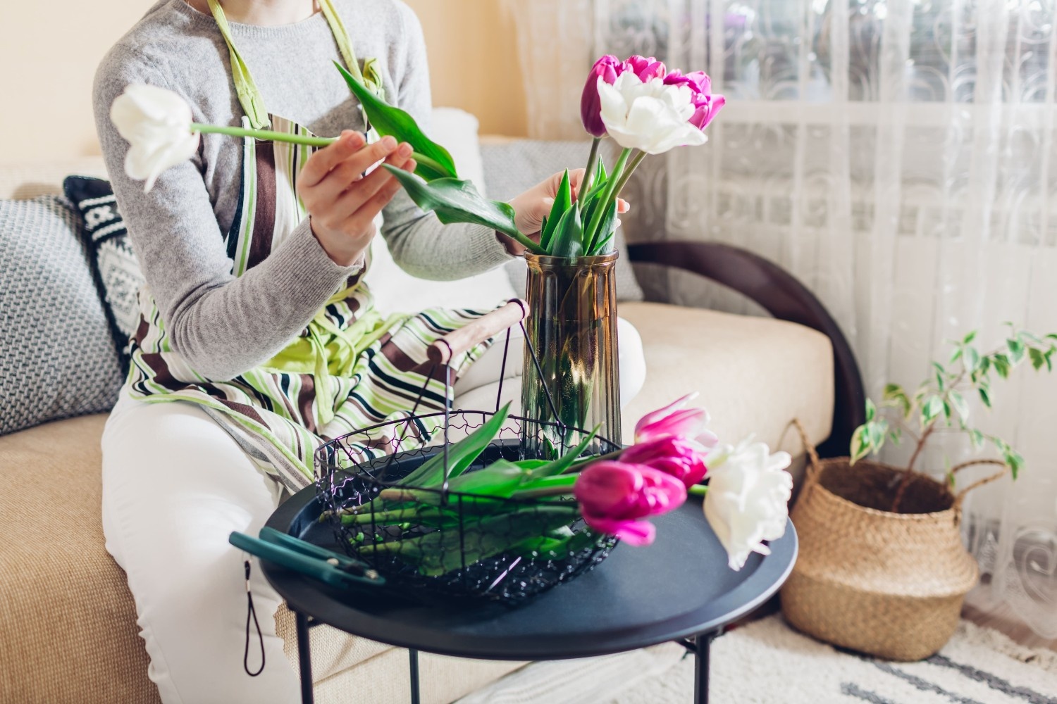 Ženska reže okrasne rože in jih postavlja v vazo