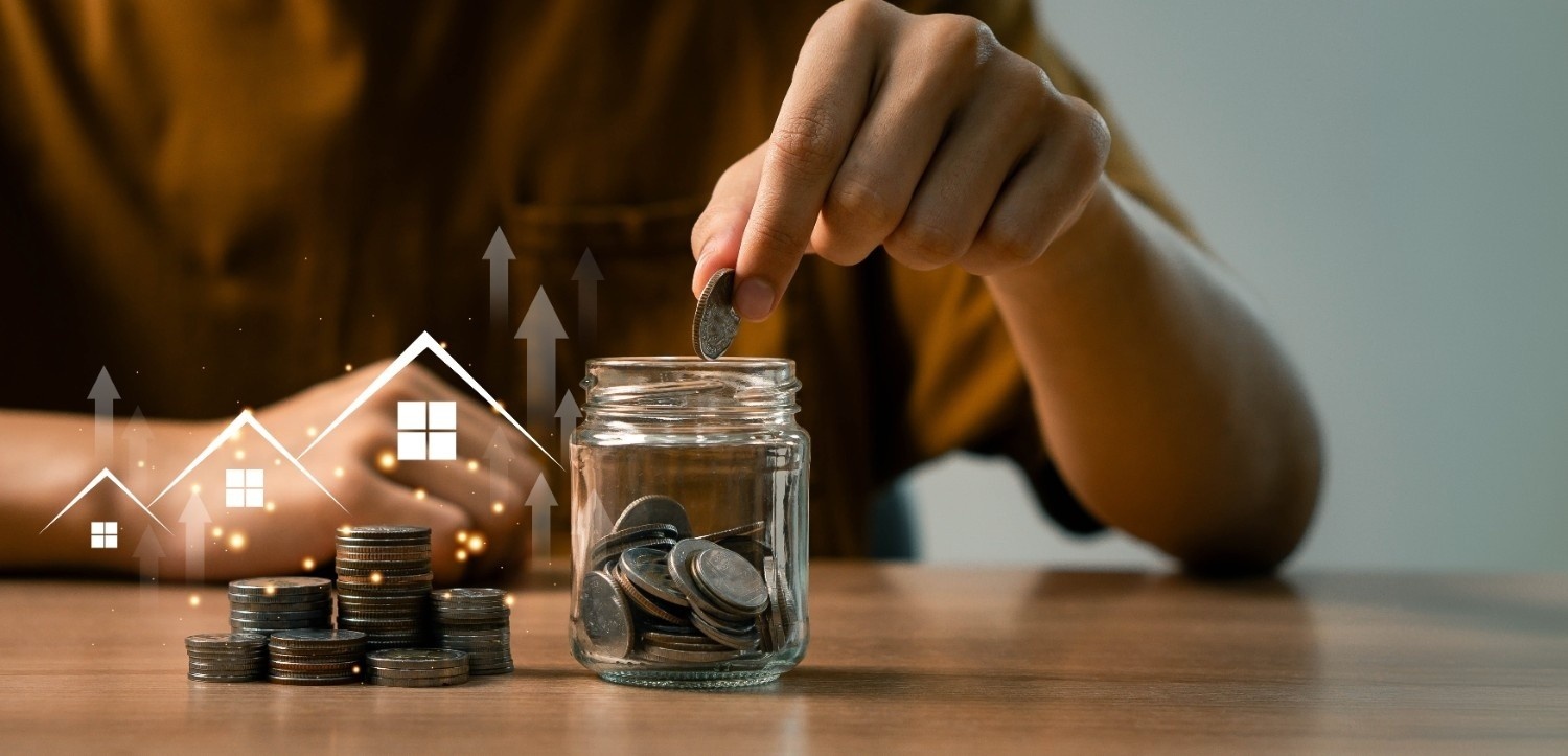 Oseba dodaja kovance v lonček za varčevanje